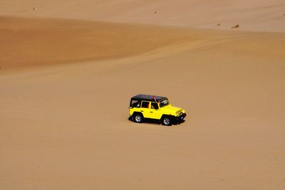 High angle view of yellow car on desert