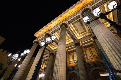 Low angle view of illuminated building against sky at night