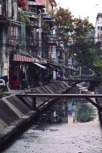 Bridge over river by buildings in city