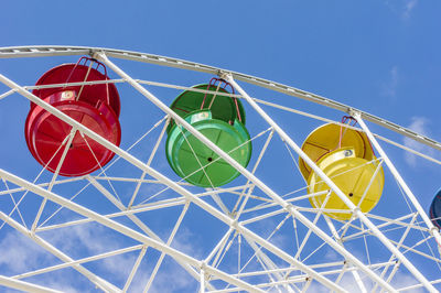 Colorful ferris wheel against blue sky with clouds