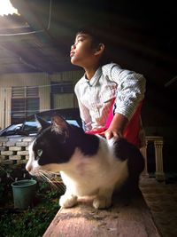 Young woman with cat standing on floor