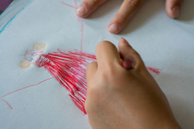 High angle view of human hand scribbling on paper