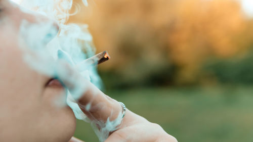 Close-up of hand holding cigarette