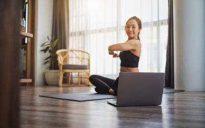 Woman learning exercise through laptop at home