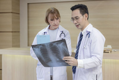 X-ray prints are examined by hospital staff. while looking at an x-ray image, two male medics