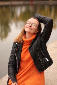 Young woman smiling by the lake, enjoying herself