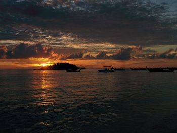 Scenic view of sea against dramatic sky during sunset