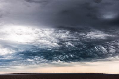 Low angle view of storm clouds over landscape