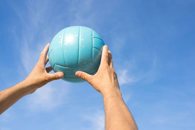 Woman hold volleyball in her hands. blue background