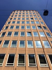 Low angle view of office building against blue sky