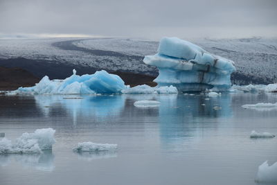 Ice floating on sea against sky