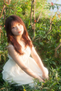 Portrait of young woman sitting on field