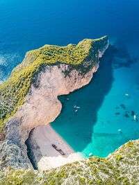 High angle view of rocks in sea against blue sky