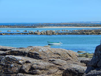 Boat on sea against clear blue sky