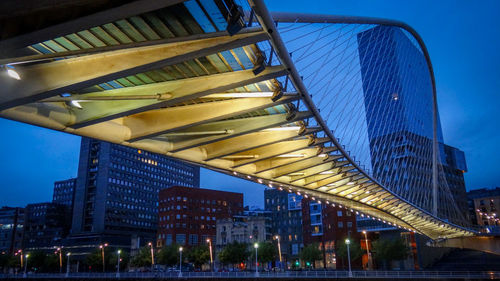 Low angle view of illuminated bridge against sky at dusk