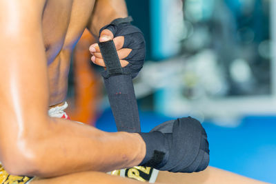 Close-up of human hand against blue sky