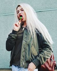 Portrait of young woman eating lollipop