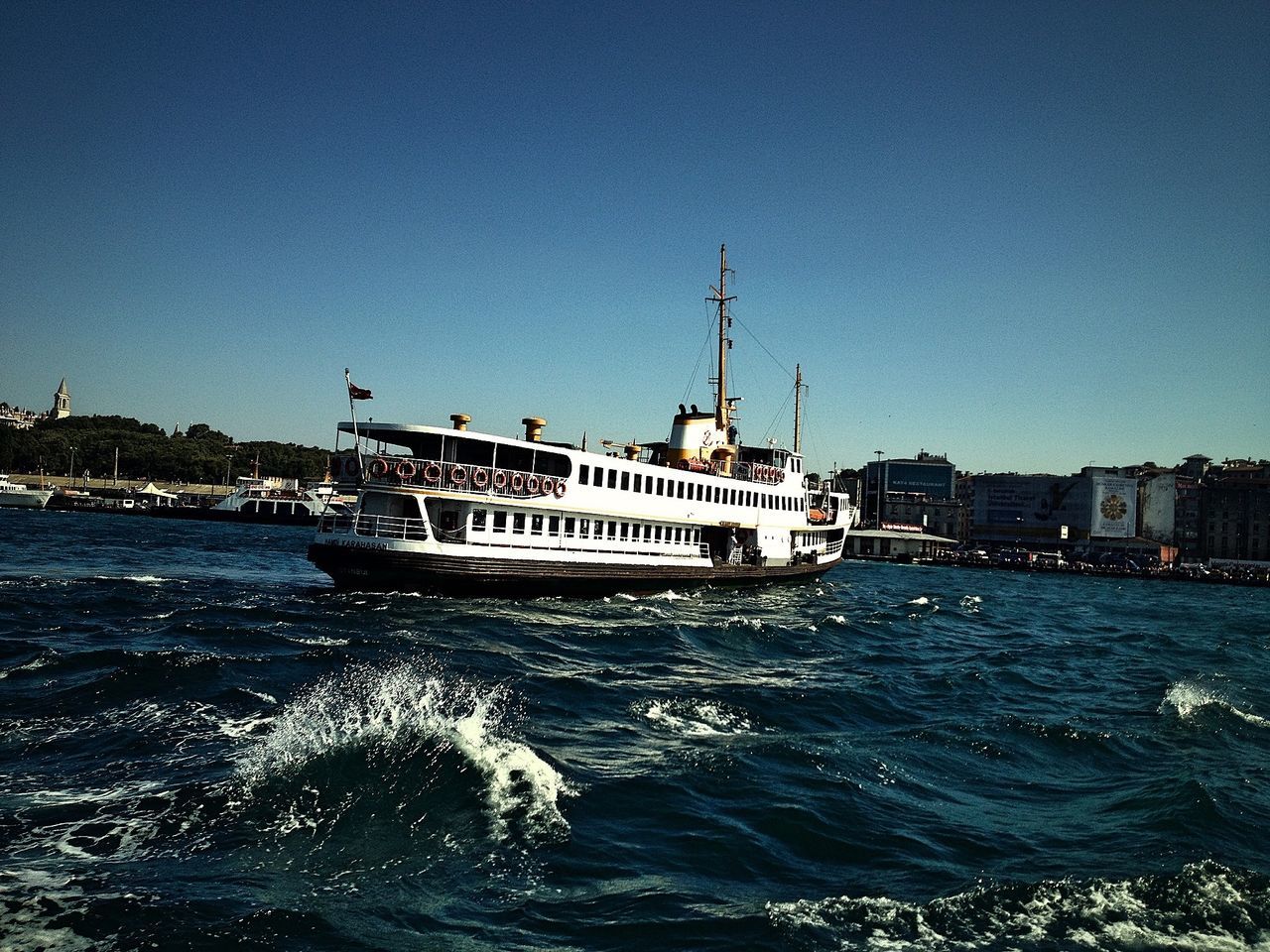 water, building exterior, architecture, built structure, clear sky, waterfront, blue, sea, copy space, nautical vessel, rippled, city, transportation, mode of transport, river, boat, outdoors, sky, day, nature