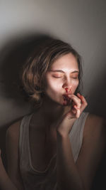 Portrait of young woman sucking your finger