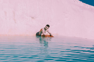 Woman sitting in swimming pool