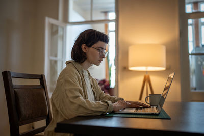 Young woman using laptop at home