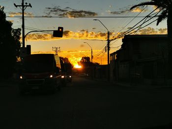 Cars on street in city at sunset