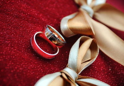 Close-up of wedding rings on red cushion