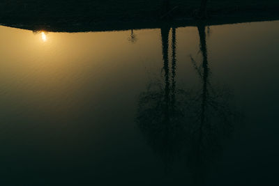 Scenic view of lake against sky at sunset