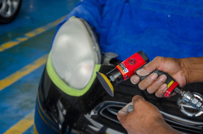 Midsection of man cleaning car at garage