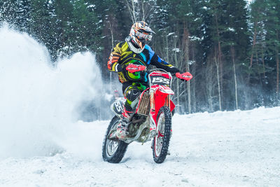 Man riding dirt bike on snow covered field