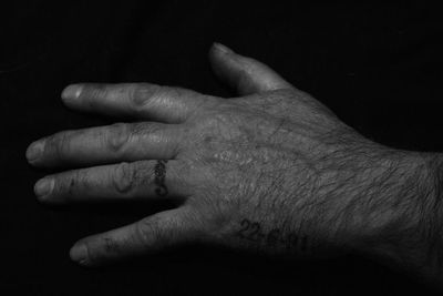 Cropped image of woman touching hand on black background