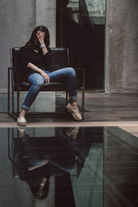 Full length of woman sitting on seat