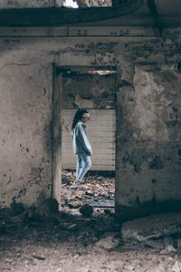 Full length of woman standing against wall