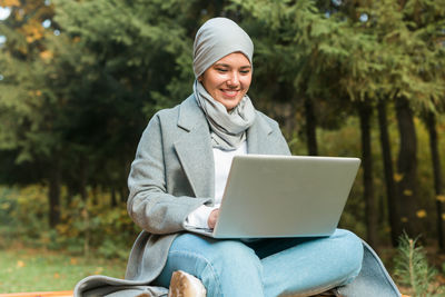 Smiling young woman using mobile phone