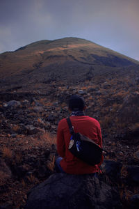 Rear view of man on mountain against sky