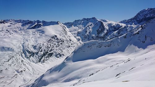 Scenic view of snowcapped mountains against clear sky