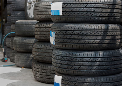 Close-up of tires stacked on street for sale