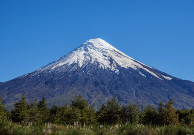 Scenic view of snowcapped mountains against clear blue sky