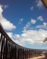 Railing against cloudy sky