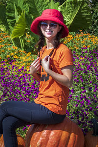 Portrait of woman sitting on purple flowering plant