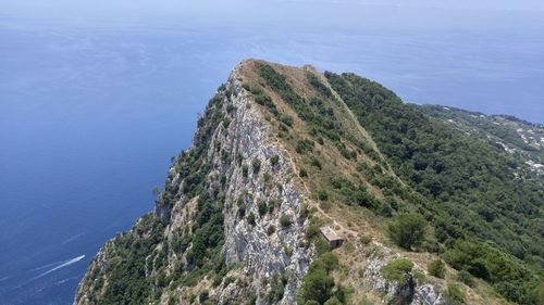 Scenic view of sea and mountains against clear blue sky