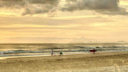 Scenic view of beach against cloudy sky