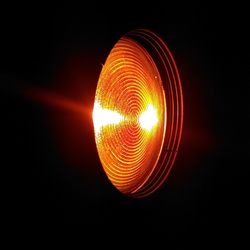 Close-up of illuminated lamp against sky at night