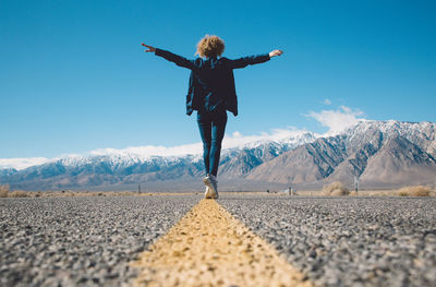 Full length of woman on snow covered mountain against sky