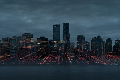 Illuminated city buildings against sky at night