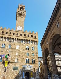 Low angle view of clock tower against blue sky