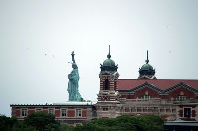Statue of liberty against built structure and clear sky