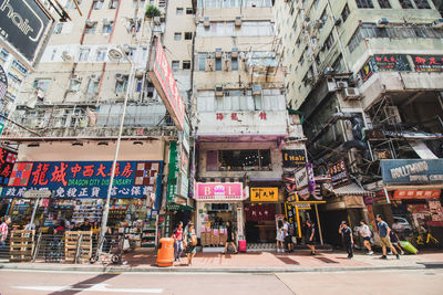 People on street amidst buildings in city