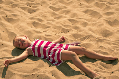 High angle view of girl lying on sand