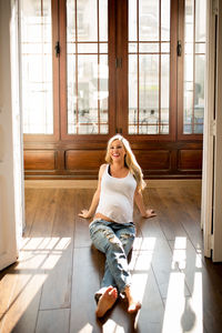 Portrait of young woman sitting on floor at home